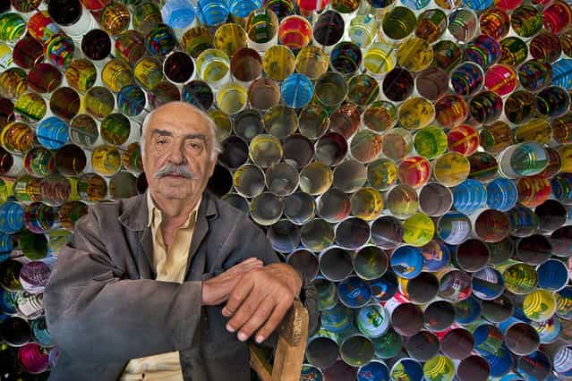 [Tinman]. Fikret the tinman lives in Tarsus. he is the expert of recycling. He makes stovepipe using tins of tomato, cheese and pickle. After I met him, I put colorful tins in a line. I took his photo of happiness, the image was like a honey comb and a colorful rainbow. Location: Turkey, Tarsus. (Photo and caption by Melih Sular/National Geographic Traveler Photo Contest)