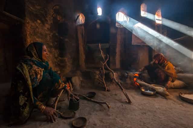 [The Bread Makers]. Two Omani women making traditional arabic bread over an open fire. (Photo and caption by Darryl MacDonald/National Geographic Traveler Photo Contest)