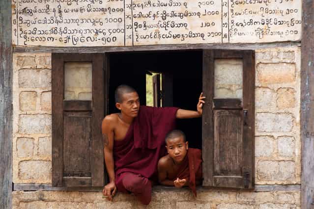 [Buddhist monks]. At the hills around Kalaw (Myanmar) there are a number of villages that are accessible only by foot. Daily several small groups of tourists visit these villages. These two monks were looking at the tourists who just entered the Palaung village. (Photo and caption by Paul Klaassen/National Geographic Traveler Photo Contest)