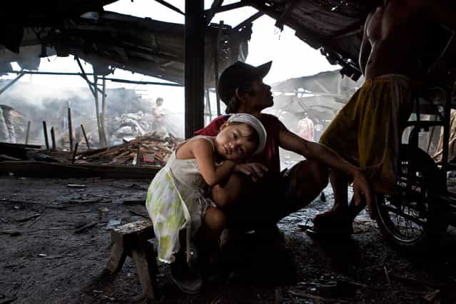 [The city of coal]. In the slum area of Ulingan, near Manila, hundreds of families earn their living from the charcoal industry. The air is thick with smoke as children and adults of all ages get to work. Families have lived in these conditions for generations but now a project to test smokeless kilns is under way, and local NGO Project Pearls is helping to ensure that children living in the slum receive a few decent meals a week and some education. Location: Philippines, Manila. (Photo and caption by Claudio Ceriali/National Geographic Traveler Photo Contest)