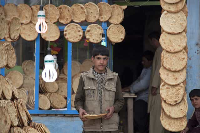[Afghan Bread]. This image of a bread seller was captured on a morning, in Herat's neighborhood, March 2013. Location: Herat, Afghanistan. (Photo and caption by Ricardo Thome/National Geographic Traveler Photo Contest)