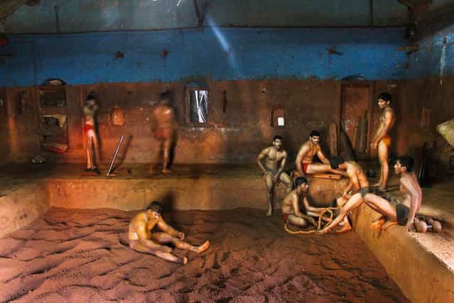 [Kushti – Wrestling in soil]. Kusti is means wrestling. This construction is made around 1895 by one of the great king of Kolhapur [Shau Maharaj] who was very modern in his thinking and he promoted this game with things like education and agriculture. he gets credit of building first water dam in India in 1909. This building in totally made from clay. The soil in wrestling area is specially prepaired for this game which contain lot of Aurveda medicines like turmeric, honey and many more. This soil is good for skin and wrestler from all over India taking benefit of it from last 125 years. Location: Kolhapur, Maharashtra, India. (Photo and caption by Indrajit Khambe/National Geographic Traveler Photo Contest)