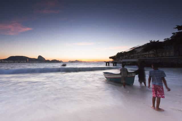 [Fishermen kids]. These fishermen kids help their fathers on daily job, and even do the job themselves. The fishing is a common way of living for poor people in Rio de Janeiro, Brazil. This shot was a beautiful morning at Copacabana beach. (Photo and caption by Luis Gutman/National Geographic Traveler Photo Contest)