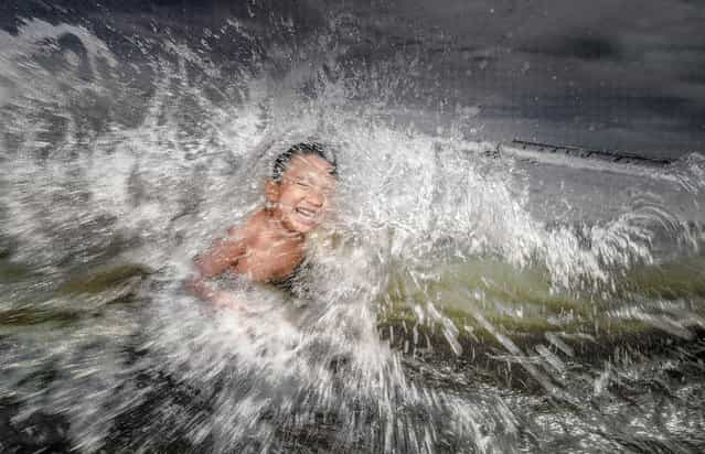 [Kid in a Roaring Wave]. A 6 years old kid playing in the beach of Enoshima Kamakura, Japan when suddenly struck by a roaring waves. (Photo and caption by Danilo Dungo/National Geographic Traveler Photo Contest)