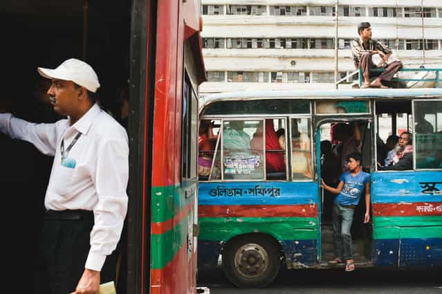 [Men on buses, Dhaka]. Passengers make their way through rush-hour traffic in one of Dhaka's public buses. Location: Dhaka, Bangladesh, Asia. (Photo and caption by Kristian Leven/National Geographic Traveler Photo Contest)