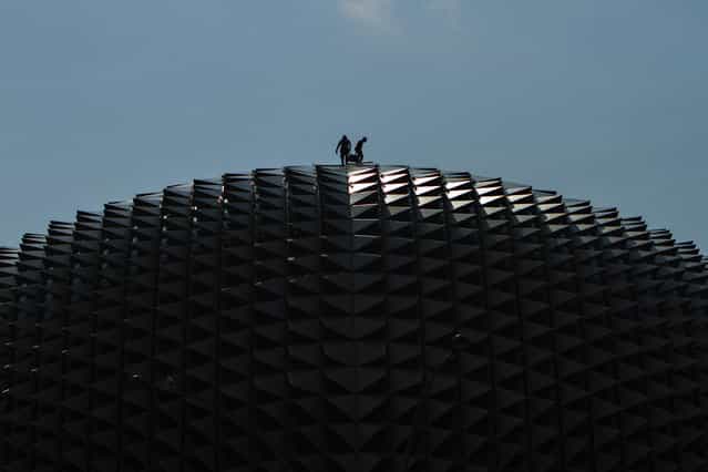 [Top Of The Roof]. The two workers were working on top of one of the world most famous theatre, the Esplanade. Location: Esplanade – Theatres On The Bay, Marina Bay, Singapore. (Photo and caption by K. W. Phua/National Geographic Traveler Photo Contest)
