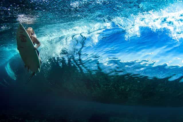 A surfer swims beneath a wave. (Photo by Sarah Lee/Caters News)