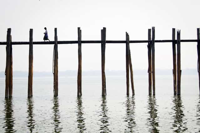 [Daybreak in Mandalay]. A moment of calm: a man walks across U-Bein Bridge before the onslaught of morning foot-traffic. Location: Mandalay, Myanmar. (Photo and caption by Jocelyn Voo/National Geographic Traveler Photo Contest)