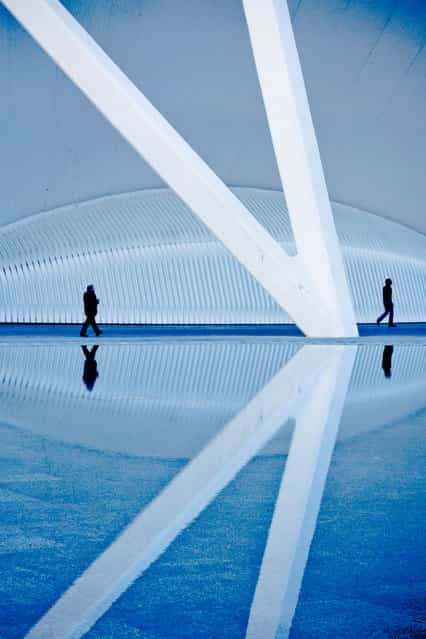 [Seeing Double]. Two figures walk along one of the reflecting pools at Santiago Calatrava's futuristic architectural wonder – The City of Arts and Sciences, in Valencia, Spain – a massive space full of lines, repetitions & reflections. Location: City of Arts & Sciences, Valencia, Spain. (Photo and caption by Erika Szostak/National Geographic Traveler Photo Contest)