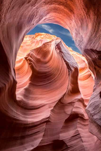 [Touch of Blue]. A slot canyon begins as a hairline crack in rock, which is beaten upon by rapidly flow

<div class=