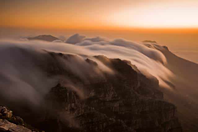[Table Mountain's Cloudy Tablecloth]. This gorgeous phenomena of clouds pouring over the top of Table Mountain in Cape Town, South Africa, is what gave the mountain it's name. I was mesmerized by this stunning, slow-motion, waterfall effect and had to capture it with my camera...which I think is impossible to ever truly capture. (Photo and caption by Laura Grier/National Geographic Traveler Photo Contest)