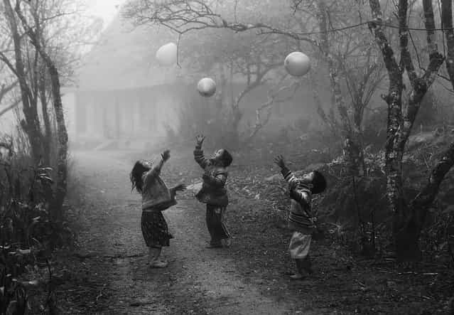 [Second Place Winner: My Balloon]. H'mong children play with their balloons on a foggy day in Moc Chau, Son La province, Vietnam; photographed January 2012. National Geographic contributing photographer Alexandra Avakian, one of this year's judges, shares her thoughts on the second place winner: This picture is like a dream, and it’s timeless not only because it’s black and white and there’s no sense of modernity, but also because it depicts an activity that children everywhere on the planet do with balloons. The fog and soft background make it feel like a memory. It’s every bit as good as the photographs in the seminal black-and-white photo book, [The Family of Man]. Sometimes the best scenes to shoot are not in the obvious places for travelers but can be found anywhere from a far-flung location – such as this remote Hmong village – to just the around the corner from a big event. (Photo and caption by Vo Anh Kiet/National Geographic Traveler Photo Contest)