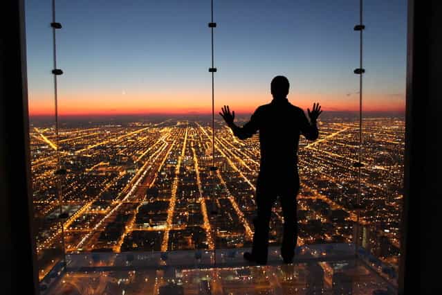 [If Only I Could Fly]. Spontaneous moment captured contemplating a beautiful and colorful sunset with all city lights down below. Location: Skydeck, Willis Tower, Chicago, Illinois. (Photo and caption by Gustavo Santos/National Geographic Traveler Photo Contest)