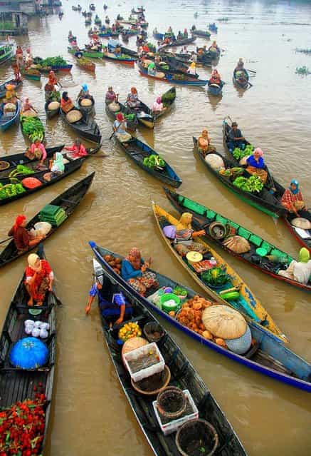 [Floating Market]. The Lok Baintan floating market is located in Banjarmasin, about an hour from central Banjarmasin by klotok (traditional boat). Trading begins early in the morning and traders sell and barter freshly harvested fruits and vegetables. Location: Lok Baintan, South Borneo, Indonesia. (Photo and caption by Hary Muhammad/National Geographic Traveler Photo Contest)