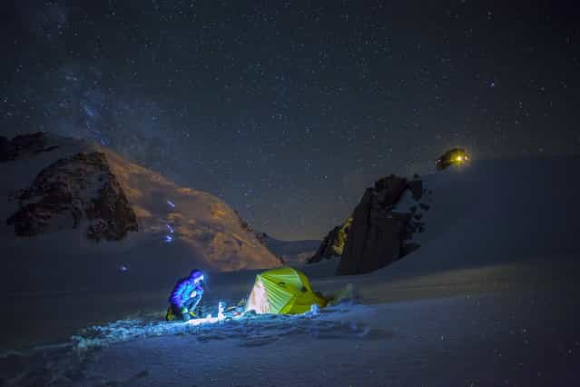 [A snapshot from mountaineer's life]. Have you ever wondered how does a mountaineer's day start? I will give you a hint: you wake up at 3 am, set the stove, wake up your partner, pretend it is warm, quickly consume a high-calorie breakfast, watch your friends slowly ascending the icy slopes of your dream summit with their tiny head torches glimmering against perfectly blue ice, and hope for the good weather. One would ask: why all this trouble? The answer is easy: for the love of the adventure and the unknown. Location: Chamonix, Haute Savoye, France. (Photo and caption by Kamil Tamiola/National Geographic Traveler Photo Contest)