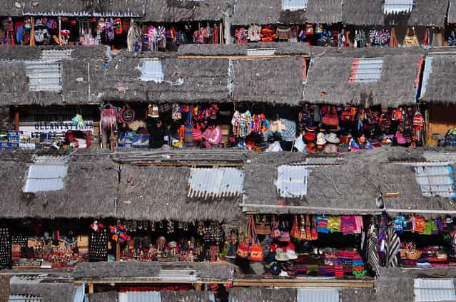 [Souvenir Market]. A small souvenir market selling wares with vibrant colors as seen from the top of the Inca remains in the town of Ollantaytambo, some 60 km from Cusco. Location: Ollantaytambo, Peru. (Photo and caption by Ben Leshchinsky/National Geographic Traveler Photo Contest)