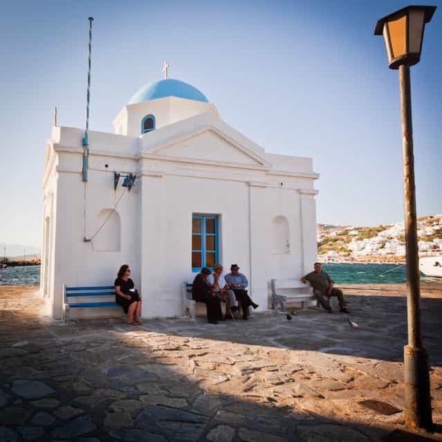 [Leisurely Greek Afternoon]. I took this photo in Mykonos, Greece. I loved how the three men in the middle were deep in conversation while there was one person on each bench on either side of them gazing off into the distance. I also loved the warm afternoon sun. (Photo and caption by Angie McMonigal/National Geographic Traveler Photo Contest)