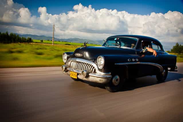 [Cruising in Cuba]. The National Highway in Cuba has many stretches where you will not see another car for miles. Then when you do see one, it is an old classic like this 1950's Buick which looks at home on the open road with the Cuban landscape of fields and mountains in the distance. (Photo and caption by James Kao/National Geographic Traveler Photo Contest)