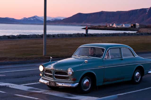 [Twilight on the road]. The sun has gone down the horizon. I was going to leave the bay road when I saw this old volvo waiting for the green light. The car, the lady and the twilight, It's a beautiful silent moment. Location: Reykjavik, Iceland. (Photo and caption by Weixin Shen/National Geographic Traveler Photo Contest)