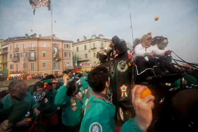 [Battle of the Oranges]. During the Battle of the Oranges alongside Tuchini del Borghetto team wearing green and red. Just before the throw. 19 of February 2012, Ivrea Italy. (Photo and caption by Lydia Pagoni/National Geographic Traveler Photo Contest)
