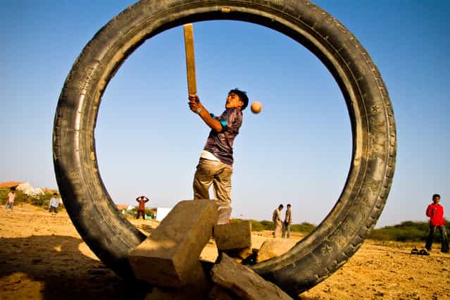 [Village Boys play cricket in Gujurat, India]. Cricket is the passion and preferred pastime of almost every Indian boy. Just outside their small community in Eastern Gujurat, locals don't let scarcity of resources dull their fervour – improvising with an old tire for wickets and plank of wood for a bat. (Photo and caption by Danny Pemberton/National Geographic Traveler Photo Contest)