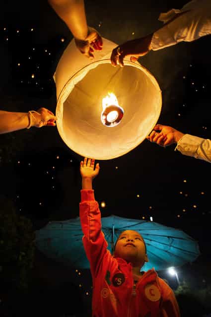 [Yi Peng Festival]. A little girl and her family launch a sky lantern or khom loy – as its known in Thailand – during the Yee Peng Festival in Chiang Mai. By releasing the lanterns to the sky the Thai people believe they are sending kindness and goodwill to humankind. This festival has been taken place for around 700 years in the North of Thailand. (Photo and caption by John Quintero/National Geographic Traveler Photo Contest)