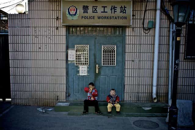[Guarding a Police Workstation]. 2 small boys playing outside a local police station. Location: Shong Shu Jie, Beijing, China. (Photo and caption by Ben Longland/National Geographic Traveler Photo Contest)
