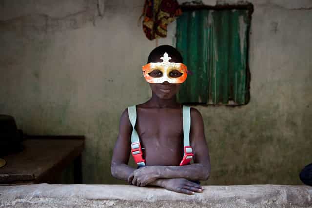 [The face of cultural fusion – Gambian village boy in a Mardi Gras mask]. On the final night of a 2 month, 1130km expedition down the River Gambia in West Africa, we pulled into the riverside village of Mandinari in The Republic of The Gambia to find a place to sleep. We entered a family compound and a young boy appeared wearing a Mardi Gras mask. At first I assumed it must be for special occasion or ceremony; no, he said just enjoyed wearing it. No, he did not know what Mardis Gras was, just that he found it at the village market. His portrait was the last one I made on the expedition and for me became symbolic of global cultural influences happening in Africa. (Photo and caption by Jason Florio/National Geographic Traveler Photo Contest)