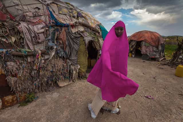 [My House]. Photo of Amna a somalian girl standing in front of her small house made from a tiny woods and clothes, living with her parents and her nine brothers and sisters. Photo taken in monday 24th of septemper 2012 during a Surgical camp from Kuwait. Location: Borama, Somalia. (Photo and caption by Mohammed Alsultan/National Geographic Traveler Photo Contest)