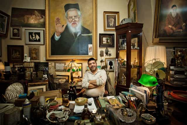 [The Art Dealer]. An art dealer at his office desk, shot in Jaffa's flea market, Israel. (Photo and caption by Lior Patel/National Geographic Traveler Photo Contest)