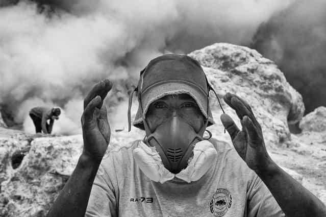 [Working in the hell]. This shot was done in a moment of break of this young guy who works every day as a miner of sulfur in the crater of the volcano Kawa Ijen, southeast of the of Java island, Indonesia. Is one of the most wasting jobs imaginable, work in extreme conditions with high temperatures, toxic exhalations that burning eyes and lungs. The stated life expectancy is 50 years and this guy is more fortunate than other boys like him because he can afford the luxury of working with a mask to filter toxic substances. (Photo and caption by Dario Ruta/National Geographic Traveler Photo Contest)