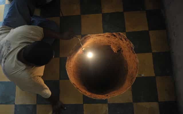 A man inspects a sinkhole formed in a house on July 19, 2011 in the north of Guatemala City. When neighbors heard a loud boom overnight they thought a gas canister had detonated. Instead they found a deep sinkhole inside a home in a neighborhood just north of Guatemala City. The sinkhole was 12.2 meters (40 feet) deep and 80 centimeters (32 inches) in diameter, an AFP journalist who visited the site reported. Guatemala City, built on volcanic deposits, is especially prone to sinkholes, often blamed on a leaky sewer system or on heavy rain. (Photo by Johan Ordonez/AFP Photo via The Atlantic)
