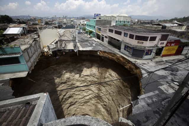 A giant sinkhole caused by the rains of tropical storm Agatha is seen in Guatemala City June 1, 2010. Collapsed roads and highway bridges complicated rescue efforts in Guatemala on Tuesday after Tropical Storm Agatha drenched Central America, burying homes under mud and killing at least 175 people. (Photo by Daniel LeClair/Reuters via The Atlantic)
