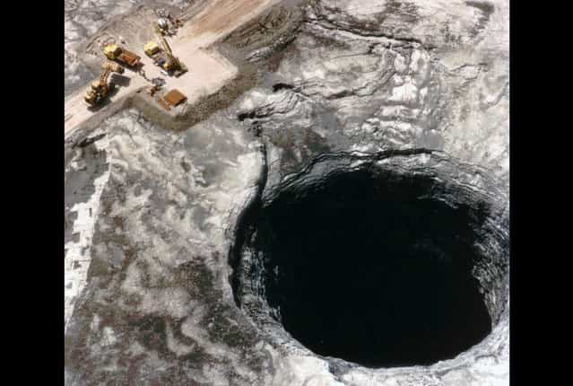 In June of 1994, a huge hole, 106 ft. wide by 185 ft. deep, opened in the center of an IMC-Agrico waste stack near Mulberry, Florida. The sinkhole, shown in this July 13, 1994 photo, released 20.8 million pounds of liquid phosphoric acid into the ground below, and into the Floridan aquifer, which provides 90 percent of the state's drinking water. The company voluntarily spent $6.8 million to plug the sinkhole and control the spread of contaminants in the ground water. (Photo by AP Photo/Selbypic via The Atlantic)