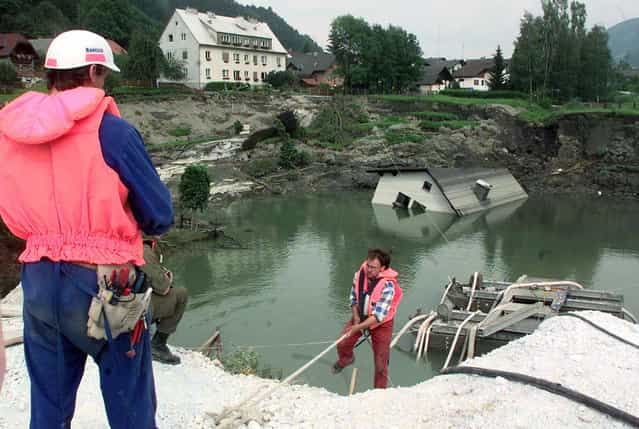 The Lassing mining disaster. On July 17, 1998 a Talc mine below the town of Lassing, Austria, experienced a partial collapse, filling with groundwater and opening up a sinkhole in the town above. Shortly after, a rescue crew of 10 men went into the mine to search for a single missing miner, and a massive collapse followed, opening up an even larger crater above. The first missing miner was found alive after ten days, but all ten of the rescue team members were killed. Here, workers examine the crater, on July 22, 1998. (Photo by Martin Gnedt/AP Photo via The Atlantic)