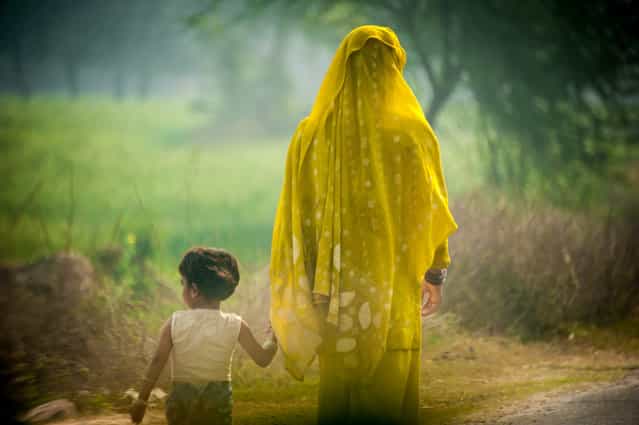 [Motherhood]. Calm Silence shared between a mother and daughter amongst the frenzied traffic along the road to Agra. Location: Somewhere between Delhi & Agra, India. (Photo and caption by Darrell Lew/National Geographic Traveler Photo Contest)