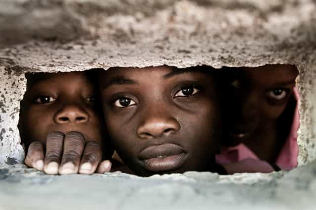 [Behind the Wall]. Pupils from the school of Degerme behind the wall of the school. Location: Abricots, Grand'Anse department of Haiti. (Photo and caption by Christophe Stramba-Badiali/National Geographic Traveler Photo Contest)