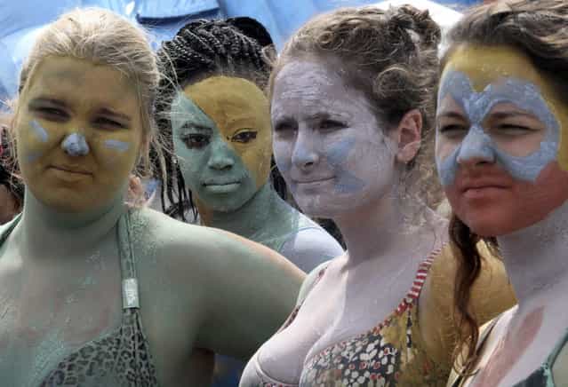 Foreign tourists make up with color mud during the Boryeong Mud Festival at Daecheon Beach in Boryeong, South Korea, Saturday, July 20, 2013. The 16th annual mud festival features mud wrestling and mud sliding. (Photo by Ahn Young-joon/AP Photo)