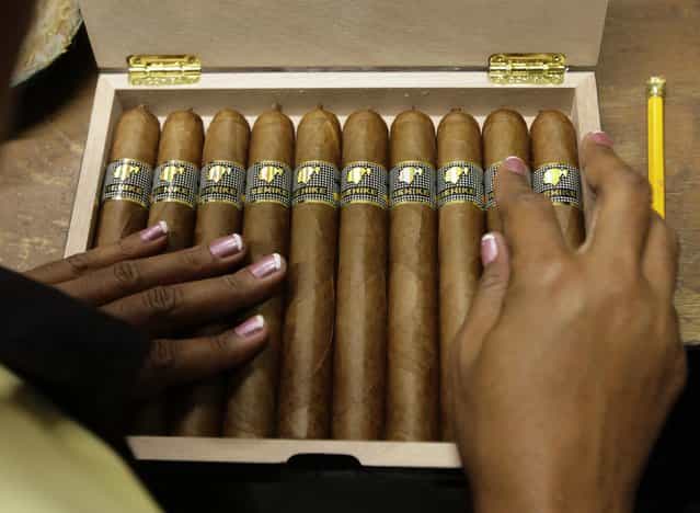 A woman fills a box of high end [Behike 56] cigars at the Cohiba factory [El Laguito] in Havana September 10, 2012. (Photo by Desmond Boylan/Reuters)