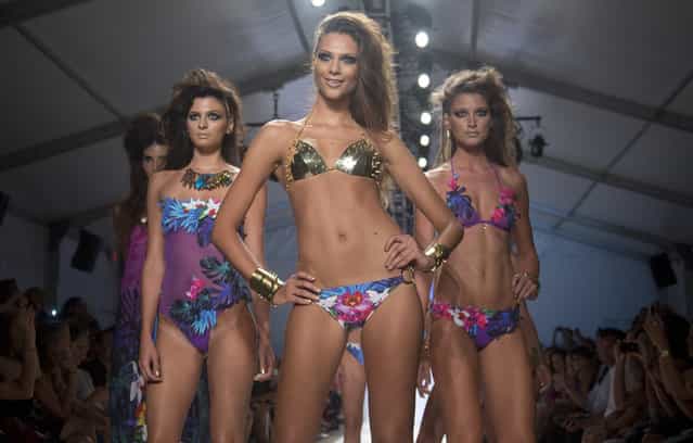 In Friday, July 19, 2013 photo, a models walk the runway during the Dolores Cortes show at the Mercedes-Benz Fashion Week Swim show in Miami Beach, Fla. (Photo by J. Pat Carter/AP Photo)