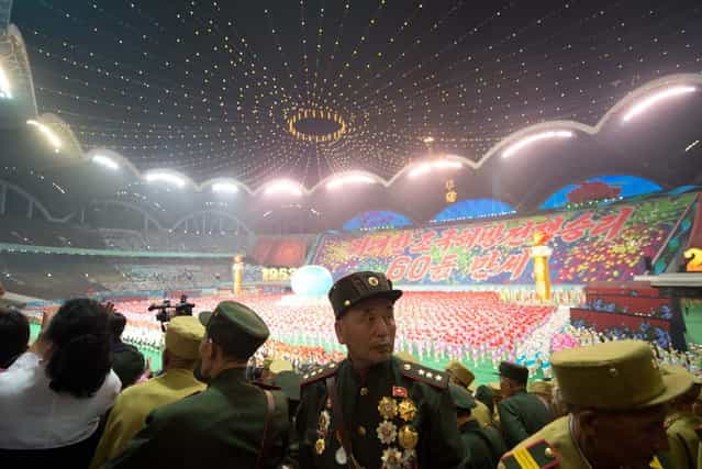 Noth Korean army veterans watch an [Arrirang Festival mass games display] at the 150,000-seat Rungnado May Day Stadiumin Pyongyang on July 26, 2013. Arrirang performances feature some 100,000 participants to create a 'synchronized socialist-realist spectacular in a 90 minute display of gymnastics, dance, acrobatics, and dramatic performance, in a highly politicized package' according to the China-based North Korean travel company Koryo Tours. North Korea is preparing to mark the 60th anniversary of the end of the Korean War which ran from 1950 to 1953, with a series of performances, festivals, and cultural events culminating with a large military parade. (Photo by Ed Jones/AFP Photo)