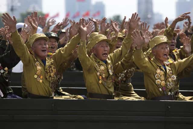 North Korean veterans of the Korean War wave to their leader Kim Jong Un during a mass military parade on Kim Il Sung Square in Pyongyang to mark the 60th anniversary of the Korean War armistice Saturday, July 27, 2013. (Photo by David Guttenfelder/AP Photo)