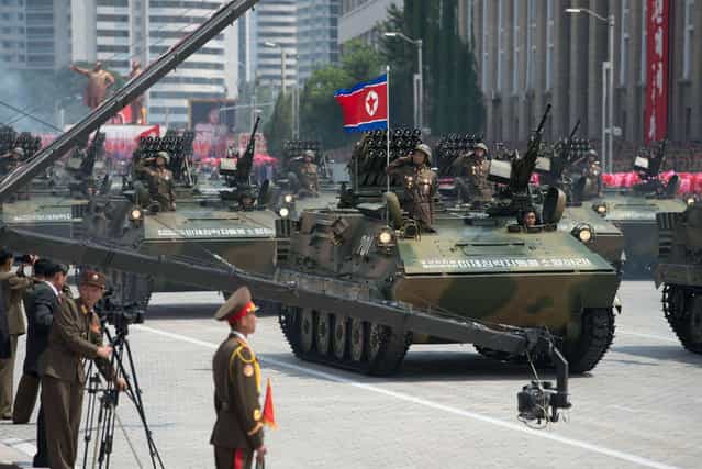 North Korean soldiers salute from a tank during a military parade past Kim Il-Sung square marking the 60th anniversary of the Korean war armistice in Pyongyang on July 27, 2013. (Photo by Ed Jones/AFP Photo)