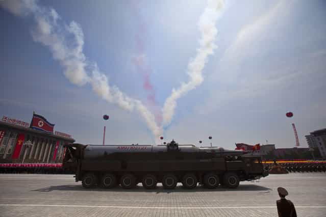 A North Korean missile rolls by as colored smoke trails, left by flying aircraft, streak the sky during a mass military parade on Kim Il Sung Square in Pyongyang to mark the 60th anniversary of the Korean War armistice Saturday, July 27, 2013. (Photo by David Guttenfelder/AP Photo)