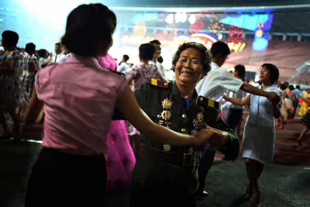 North Korean veteran Oh Gyu Sun, 78, who was a nurse in the Korean War, participates in a mass dance party during North Korean celebrations marking the 60th anniversary of the Korean War armistice, in Pyongyang, on July 28, 2013. (Photo by Wong Maye-E/Associated Press)