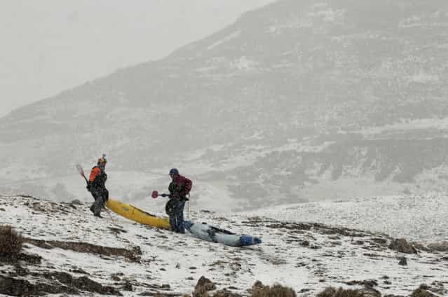 August 18, 2012 – Alpamarca, Peru – Amazon Express white water team member Rafael Ortiz, of Mexico, and expedition leader West Hansen, of Austin, Texas, portage their kayaks through a snow storm shortly after the start of white water kayaking out of Lago Acucocha. (Photo by Erich Schlegel/zReportage via ZUMA Press)