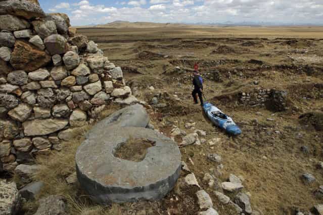 September 5, 2012 – Rio Gashan, Peru – Amazon Express expedition leader West Hansen drags his kayak through Inca ruins, including these stone grain wheels along the Rio Gashan in the Andean highlands of Peru. (Photo by Erich Schlegel/zReportage via ZUMA Press)