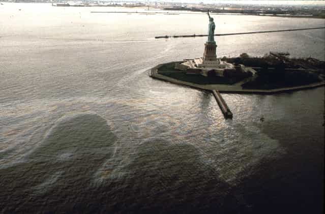 An oil slick surrounds Liberty Island in New York Harbor, in May of 1973. (Photo by Chester Higgins/NARA via The Atlantic)