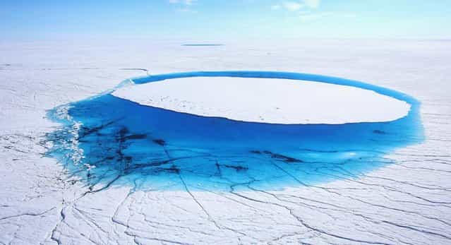 Water is seen on part of the glacial ice sheet that covers about 80 percent of the country is seen on July 17, 2013 on the Glacial Ice Sheet, Greenland. (Photo by Joe Raedle/Getty Images via The Atlantic)