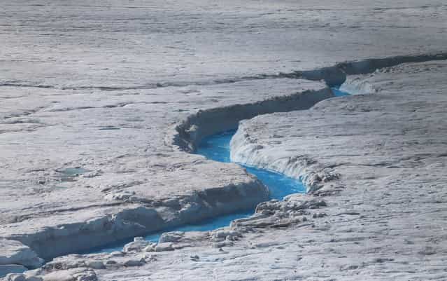 Water flows across the surface of the glacial ice sheet, photographed on July 17, 2013. (Photo by Joe Raedle/Getty Images via The Atlantic)